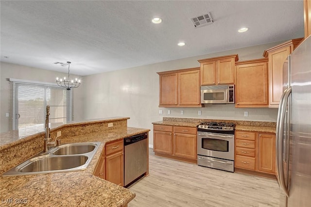 3544 Tack St, Las Vegas, NV 89122 - kitchen featuring appliances with stainless steel finishes, a chandelier, light wood finished floors, hanging light fixtures, and recessed lighting