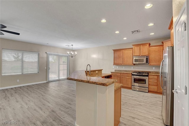 3544 Tack St, Las Vegas, NV 89122 - kitchen featuring appliances with stainless steel finishes, light wood finished floors, a ceiling fan, recessed lighting, and a chandelier