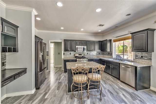 3525 Dover Bay St, Las Vegas, NV 89129 - kitchen with stainless steel appliances, a kitchen island, light stone countertops, backsplash, and recessed lighting