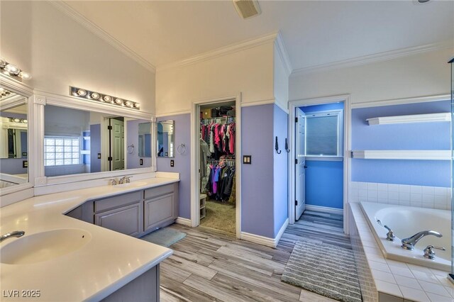 3525 Dover Bay St, Las Vegas, NV 89129 - full bathroom featuring double vanity, ornamental molding, a garden tub, wood finished floors, and a spacious closet