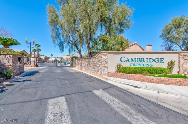 3525 Dover Bay St, Las Vegas, NV 89129 - view of asphalt street featuring a gate, street lights, a gated entry, and curbs