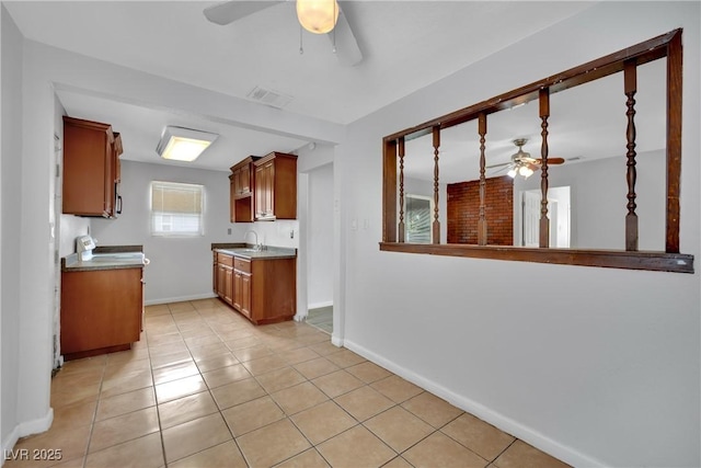75 N 27th St, Las Vegas, NV 89101 - kitchen with ceiling fan, light tile patterned flooring, and brown cabinets