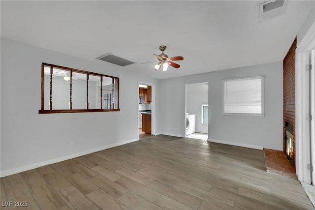 75 N 27th St, Las Vegas, NV 89101 - unfurnished living room with a ceiling fan, washer / dryer, wood finished floors, and a brick fireplace