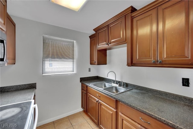 75 N 27th St, Las Vegas, NV 89101 - kitchen featuring dark countertops, light tile patterned flooring, brown cabinetry, and white electric range