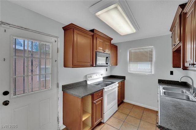 75 N 27th St, Las Vegas, NV 89101 - kitchen featuring white range with electric cooktop, black microwave, dark countertops, light tile patterned flooring, and open shelves