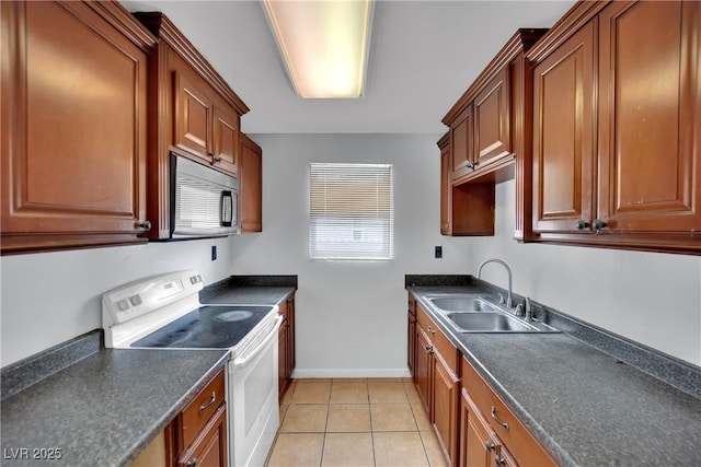 75 N 27th St, Las Vegas, NV 89101 - kitchen with white range with electric stovetop, stainless steel microwave, dark countertops, and light tile patterned floors