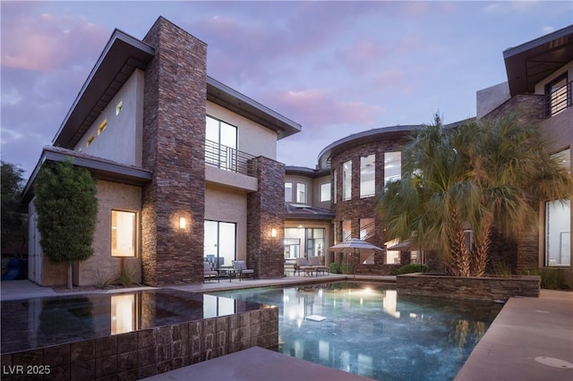 17 Soaring Bird Ct, Las Vegas, NV 89135 - pool at dusk with a patio area and a pool with connected hot tub