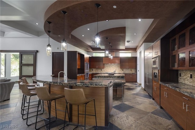 17 Soaring Bird Ct, Las Vegas, NV 89135 - kitchen featuring a spacious island, decorative backsplash, a breakfast bar area, a tray ceiling, and recessed lighting