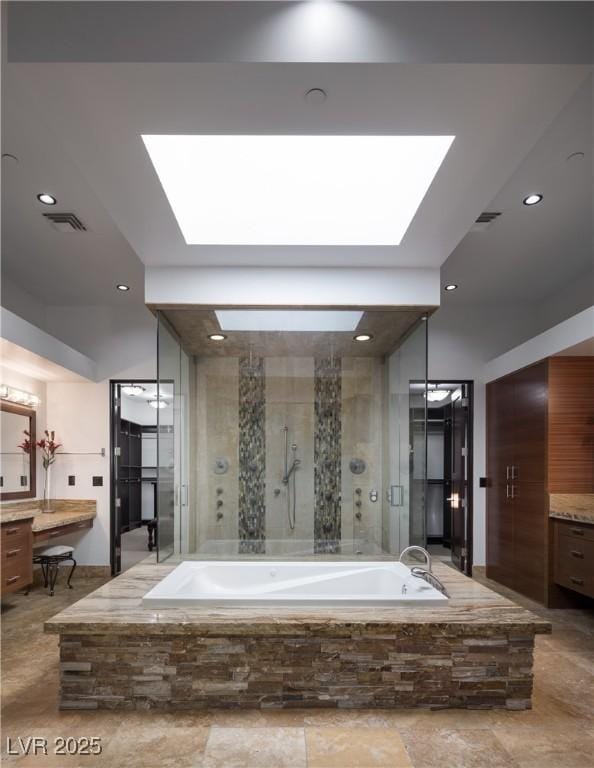 17 Soaring Bird Ct, Las Vegas, NV 89135 - full bathroom featuring vanity, a garden tub, a stall shower, recessed lighting, and a skylight