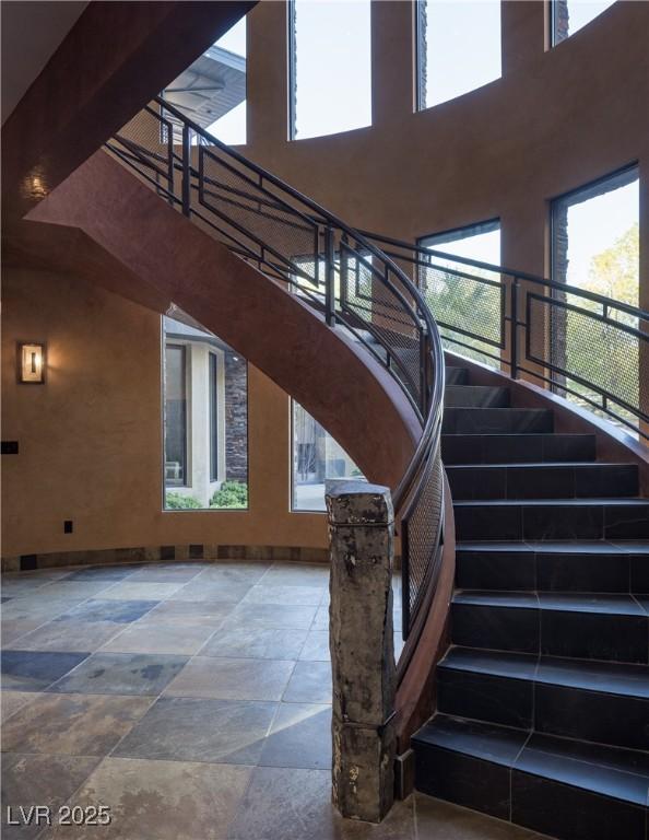 17 Soaring Bird Ct, Las Vegas, NV 89135 - staircase with a towering ceiling, stone tile floors, and plenty of natural light