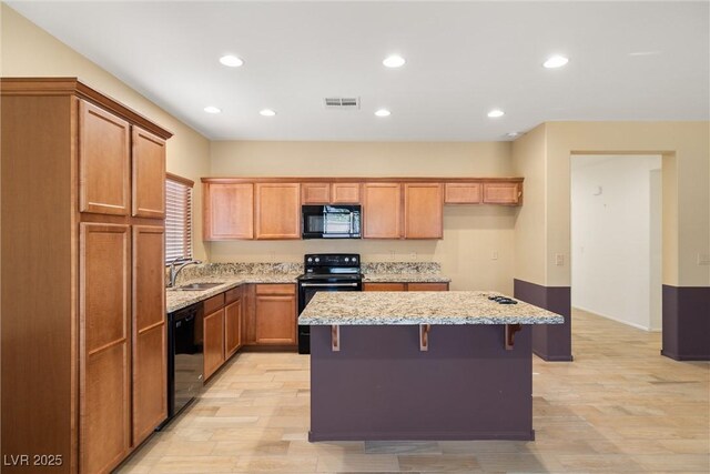 5338 Lignum Ave, Pahrump, NV 89061 - kitchen featuring black appliances, a kitchen island, recessed lighting, light stone countertops, and brown cabinetry