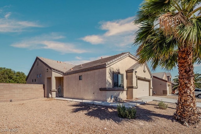 5028 Crying Heart St, North Las Vegas, NV 89031 - view of front of house with stucco siding, a garage, and driveway