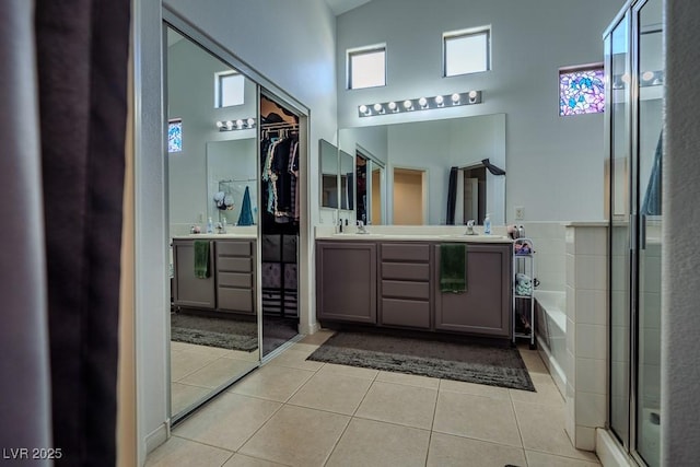 5028 Crying Heart St, North Las Vegas, NV 89031 - full bathroom with a towering ceiling, tile patterned floors, double vanity, a bath, and a stall shower
