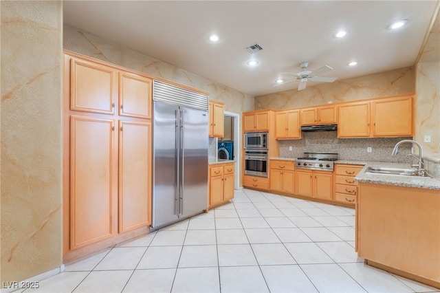10037 Summer Oak Ln Unit 102, Las Vegas, NV 89134 - kitchen with built in appliances, light brown cabinets, under cabinet range hood, ceiling fan, and light stone countertops