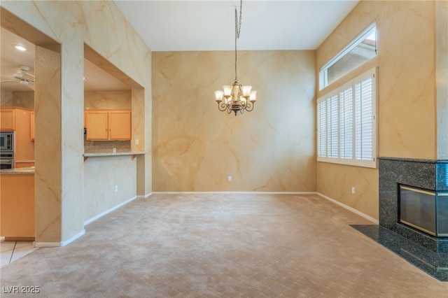 10037 Summer Oak Ln Unit 102, Las Vegas, NV 89134 - unfurnished living room featuring a tile fireplace, a chandelier, a ceiling fan, and carpet flooring