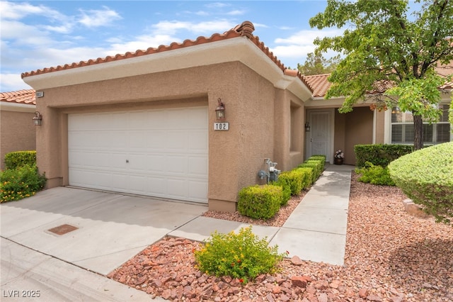 10037 Summer Oak Ln Unit 102, Las Vegas, NV 89134 - view of front of house featuring stucco siding, an attached garage, a tiled roof, and concrete driveway