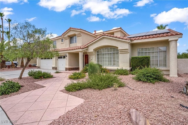 2010 Catalina Marie Ave, Henderson, NV 89074 - mediterranean / spanish house with stucco siding, solar panels, driveway, a tile roof, and an attached garage