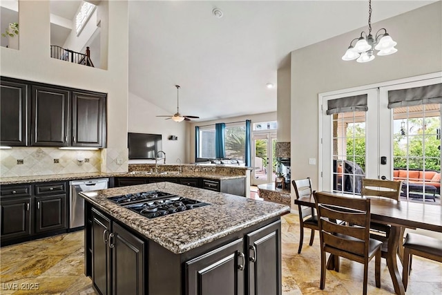 2010 Catalina Marie Ave, Henderson, NV 89074 - kitchen with stainless steel dishwasher, black gas stovetop, backsplash, a kitchen island, and a chandelier