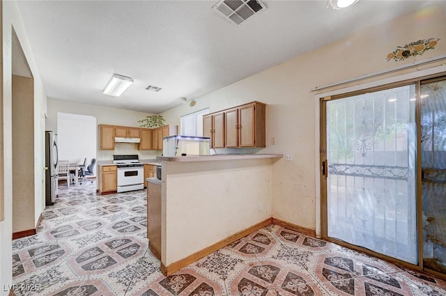 5907 Zawawi Ct, Las Vegas, NV 89110 - kitchen featuring white gas range, freestanding refrigerator, a peninsula, under cabinet range hood, and light countertops
