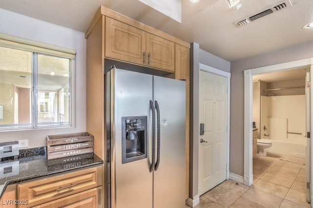 230 E Flamingo Rd Unit 203, Las Vegas, NV 89169 - kitchen with stainless steel refrigerator with ice dispenser, light tile patterned flooring, dark stone countertops, and light brown cabinetry