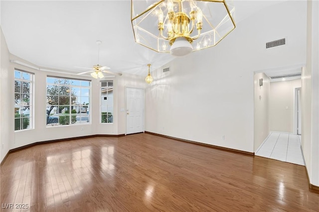 114 Tamarack Dr, Henderson, NV 89002 - unfurnished living room with wood finished floors, a ceiling fan, and a chandelier