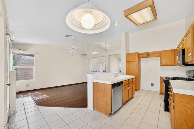 114 Tamarack Dr, Henderson, NV 89002 - kitchen featuring stainless steel appliances, light tile patterned floors, brown cabinetry, tile counters, and ceiling fan