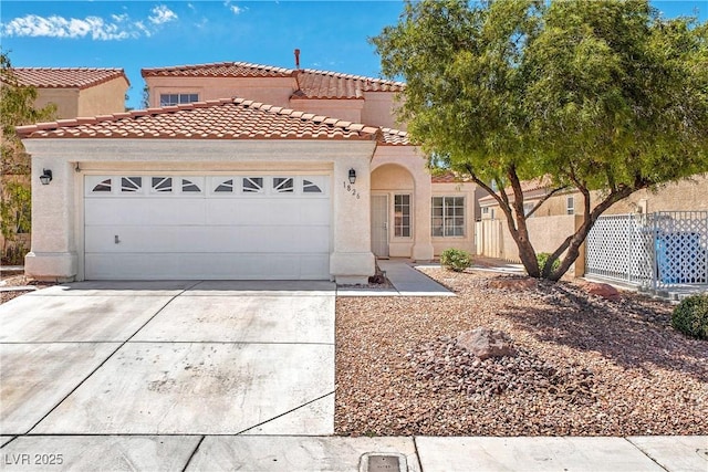 1826 Monte Alban Dr, North Las Vegas, NV 89031 - mediterranean / spanish home featuring driveway, a tiled roof, an attached garage, and stucco siding