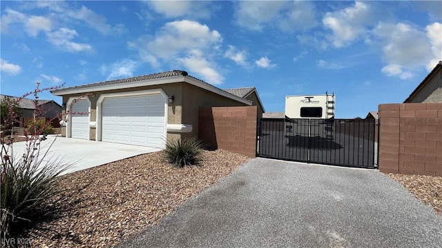 210 Magnolia Blvd, Pahrump, NV 89048 - view of home's exterior featuring driveway, a gate, a garage, and stucco siding