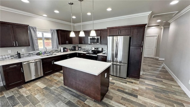 210 Magnolia Blvd, Pahrump, NV 89048 - kitchen featuring appliances with stainless steel finishes, dark brown cabinetry, ornamental molding, light countertops, and a kitchen island