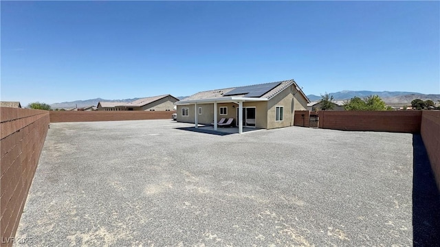 210 Magnolia Blvd, Pahrump, NV 89048 - rear view of property with roof mounted solar panels, a fenced backyard, a patio, and a mountain view