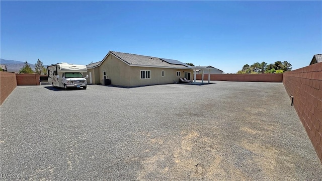 210 Magnolia Blvd, Pahrump, NV 89048 - rear view of house with solar panels and a fenced backyard