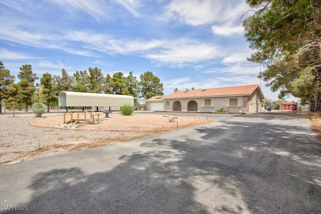 1050 Morgan Ln, Pahrump, NV 89060 - view of front of house with a tile roof, driveway, and stucco siding