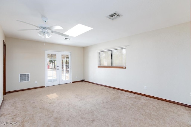 1050 Morgan Ln, Pahrump, NV 89060 - spare room with ceiling fan, french doors, carpet floors, and a skylight