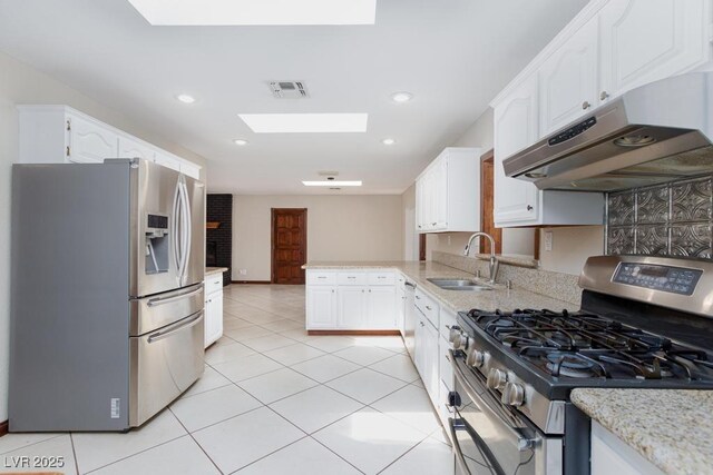 1050 Morgan Ln, Pahrump, NV 89060 - kitchen featuring appliances with stainless steel finishes, a skylight, under cabinet range hood, a peninsula, and white cabinets