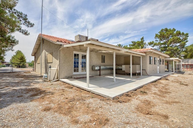 1050 Morgan Ln, Pahrump, NV 89060 - rear view of house featuring french doors, stucco siding, a tiled roof, and a patio area