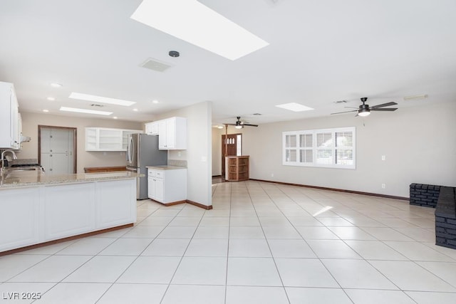 1050 Morgan Ln, Pahrump, NV 89060 - kitchen with a skylight, ceiling fan, freestanding refrigerator, a peninsula, and recessed lighting