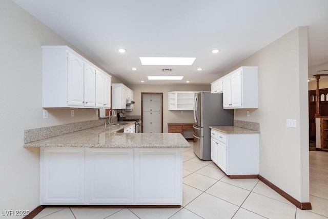 1050 Morgan Ln, Pahrump, NV 89060 - kitchen with a skylight, a peninsula, white cabinetry, appliances with stainless steel finishes, and recessed lighting