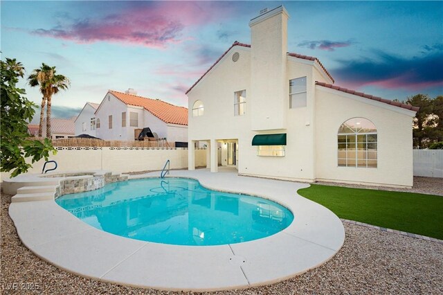 2107 Fountain Springs Dr, Henderson, NV 89074 - pool at dusk with a patio, a fenced backyard, and a pool with connected hot tub