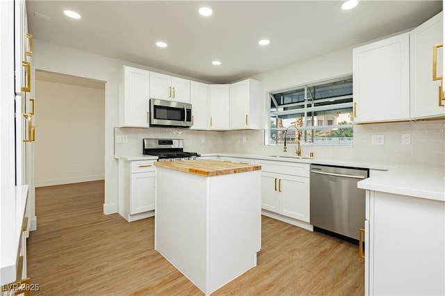 2107 Fountain Springs Dr, Henderson, NV 89074 - kitchen with appliances with stainless steel finishes, butcher block countertops, tasteful backsplash, recessed lighting, and light wood-style flooring