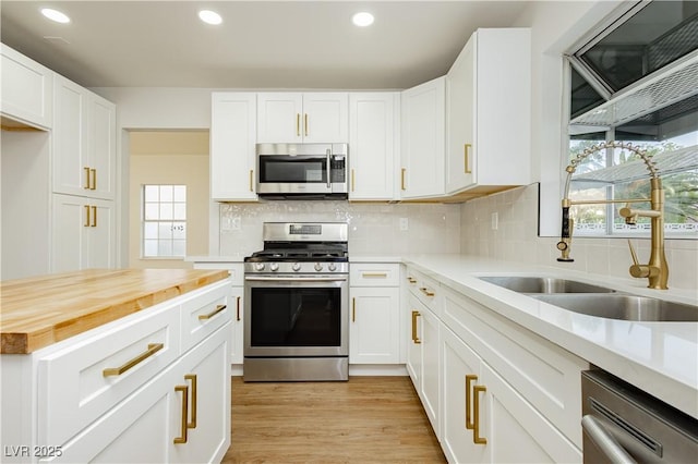 2107 Fountain Springs Dr, Henderson, NV 89074 - kitchen with appliances with stainless steel finishes, wooden counters, recessed lighting, white cabinets, and decorative backsplash