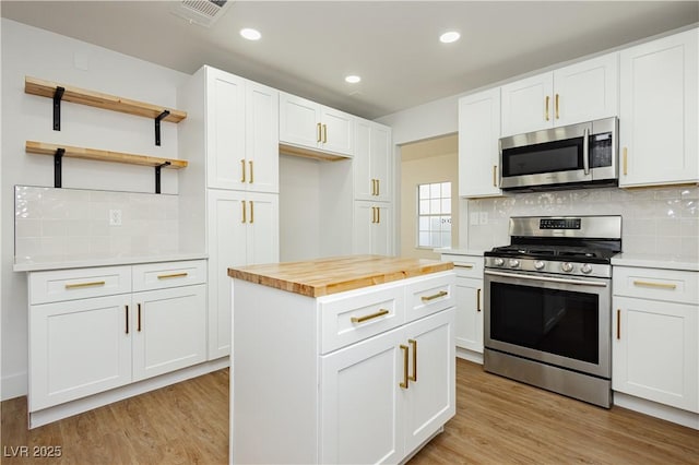 2107 Fountain Springs Dr, Henderson, NV 89074 - kitchen with appliances with stainless steel finishes, wooden counters, open shelves, backsplash, and light wood-style flooring