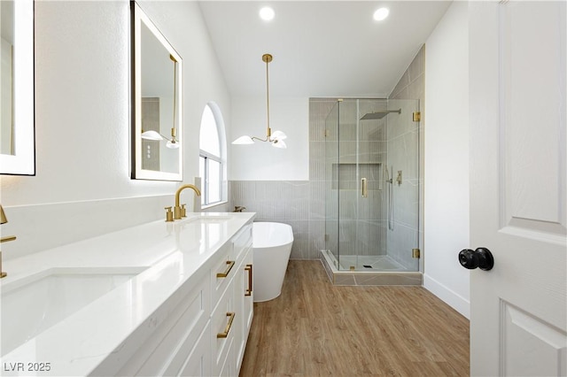 2107 Fountain Springs Dr, Henderson, NV 89074 - bathroom with a freestanding tub, double vanity, a stall shower, wood finished floors, and tile walls