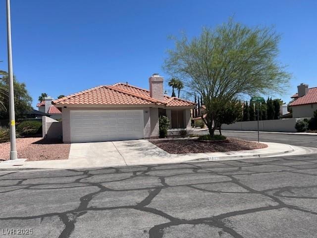 9600 Pacific View Dr, Las Vegas, NV 89117 - mediterranean / spanish-style house featuring a tile roof, stucco siding, an attached garage, driveway, and a chimney