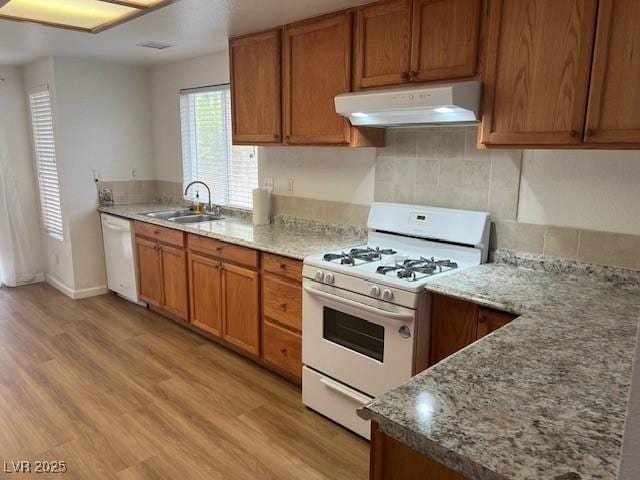 9600 Pacific View Dr, Las Vegas, NV 89117 - kitchen featuring white appliances, under cabinet range hood, backsplash, light wood-style floors, and brown cabinets