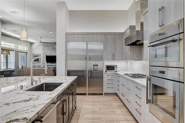 33 Hassayampa Trl, Henderson, NV 89052 - kitchen with appliances with stainless steel finishes, wall chimney exhaust hood, light stone counters, modern cabinets, and backsplash