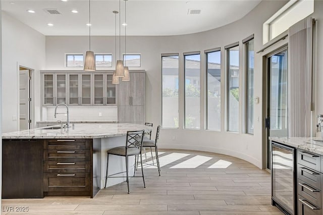 33 Hassayampa Trl, Henderson, NV 89052 - kitchen featuring beverage cooler, light wood-type flooring, decorative backsplash, healthy amount of natural light, and recessed lighting