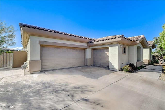 33 Hassayampa Trl, Henderson, NV 89052 - view of front of home with a tile roof, concrete driveway, stucco siding, and an attached garage