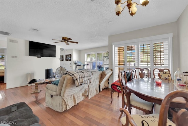 5083 Village Dr, Las Vegas, NV 89142 - living area featuring wood finished floors, a textured ceiling, a chandelier, and a ceiling fan