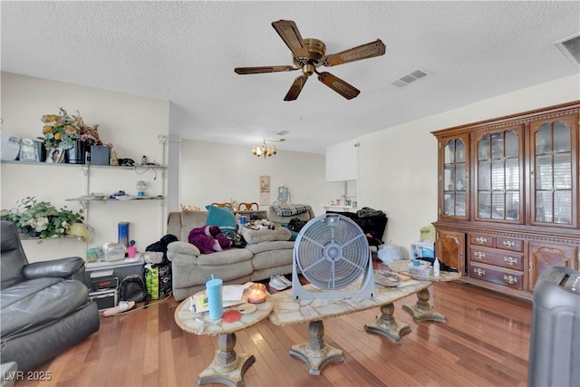 5083 Village Dr, Las Vegas, NV 89142 - living area featuring a ceiling fan, a textured ceiling, wood finished floors, and a chandelier
