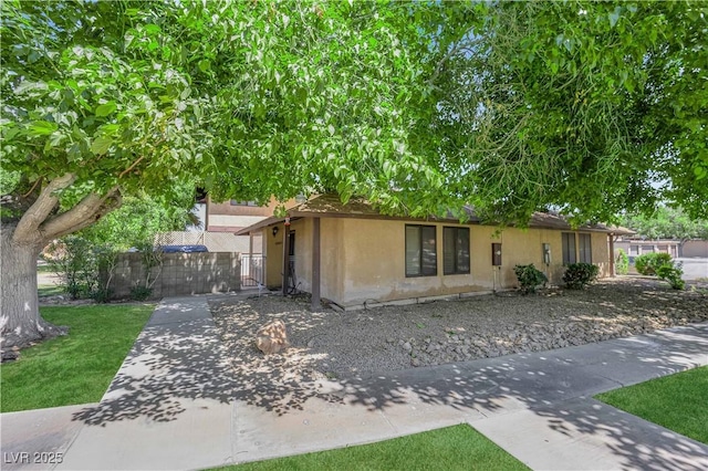 5083 Village Dr, Las Vegas, NV 89142 - view of front of home with stucco siding and a gate